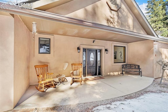 entrance to property featuring stucco siding