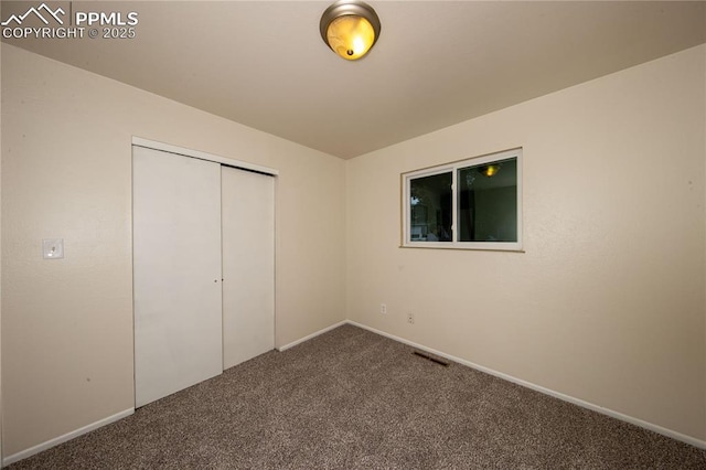 unfurnished bedroom featuring carpet floors, a closet, visible vents, and baseboards