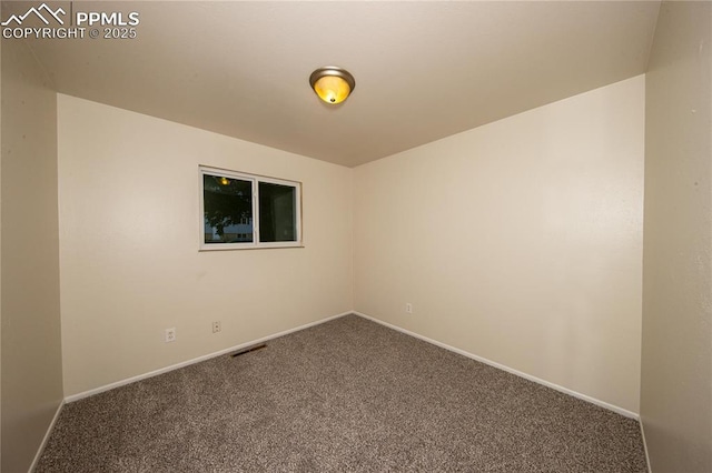 carpeted empty room featuring visible vents and baseboards