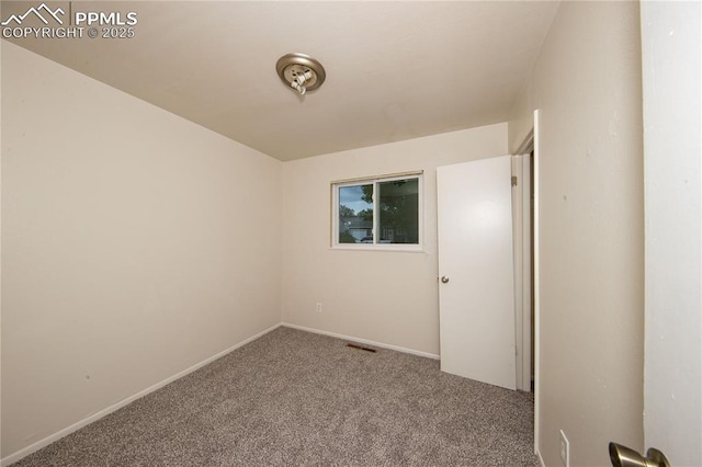 carpeted spare room featuring baseboards and visible vents