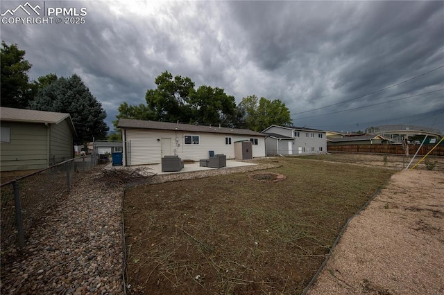 back of property with central AC, a patio area, and fence