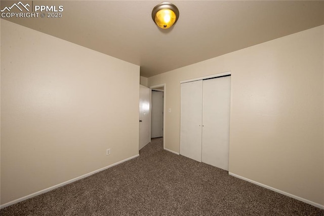 unfurnished bedroom featuring a closet, baseboards, and carpet flooring