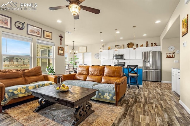 living area featuring recessed lighting, ceiling fan with notable chandelier, visible vents, baseboards, and dark wood-style floors