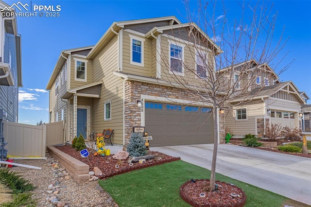 craftsman-style house featuring stone siding, fence, concrete driveway, and an attached garage