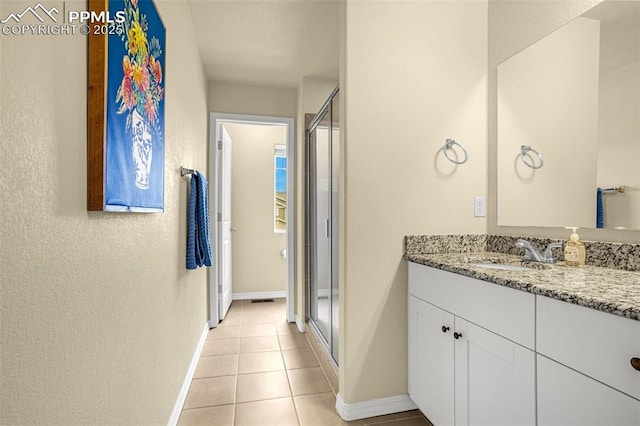 full bathroom featuring tile patterned floors, a shower stall, baseboards, and vanity