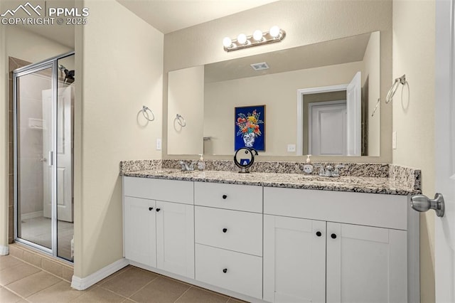 full bath featuring a sink, visible vents, a shower stall, tile patterned floors, and double vanity