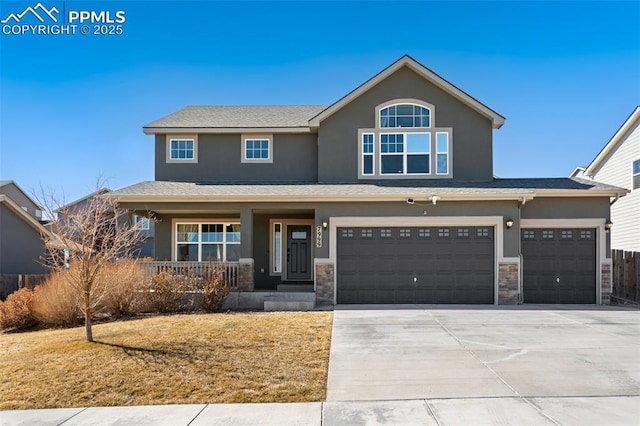 view of front of home featuring driveway, a porch, stone siding, and stucco siding