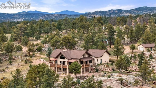 birds eye view of property with a mountain view and a view of trees