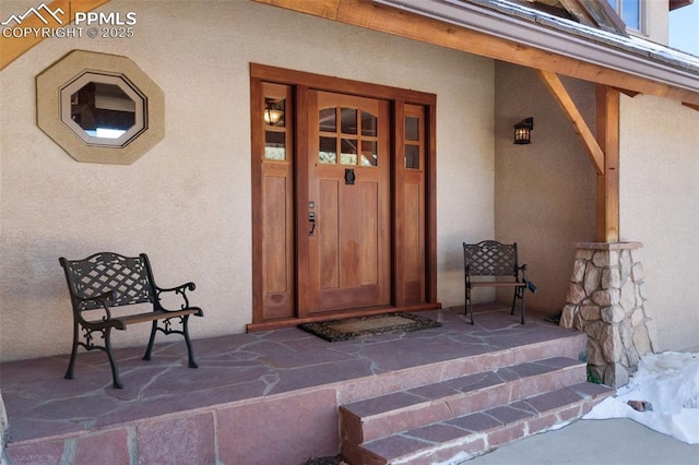 entrance to property featuring covered porch and stucco siding