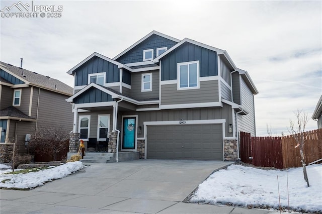 craftsman-style home with fence, board and batten siding, stone siding, and a garage