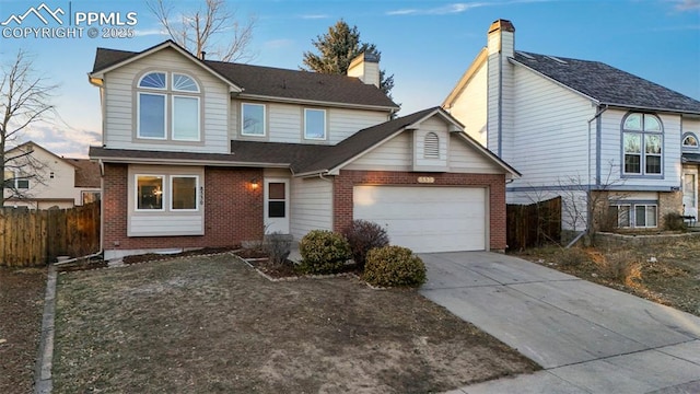 traditional-style home with concrete driveway, brick siding, fence, and an attached garage