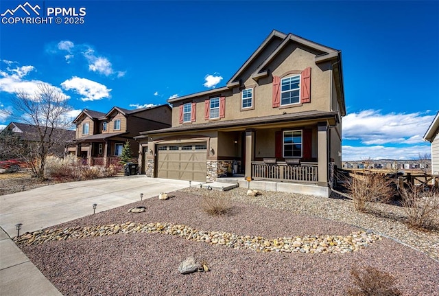 view of front of house with a porch, concrete driveway, stone siding, and stucco siding