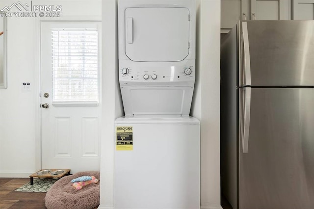 washroom with laundry area, wood finished floors, and stacked washer and clothes dryer