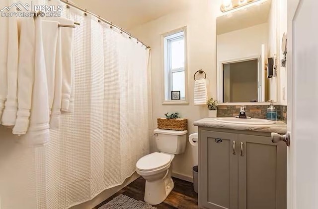 full bath with toilet, a shower with curtain, wood finished floors, vanity, and backsplash