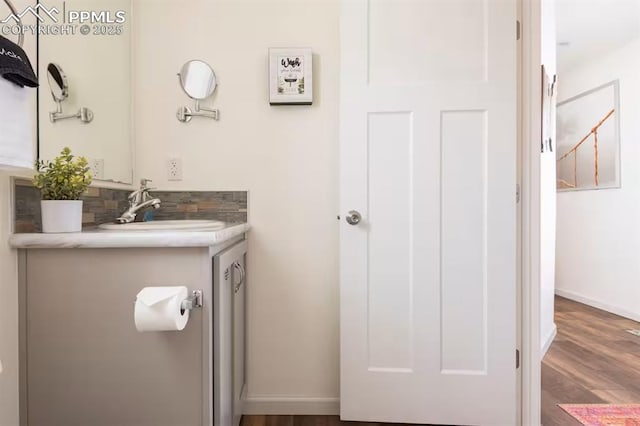 bathroom with vanity, baseboards, and wood finished floors