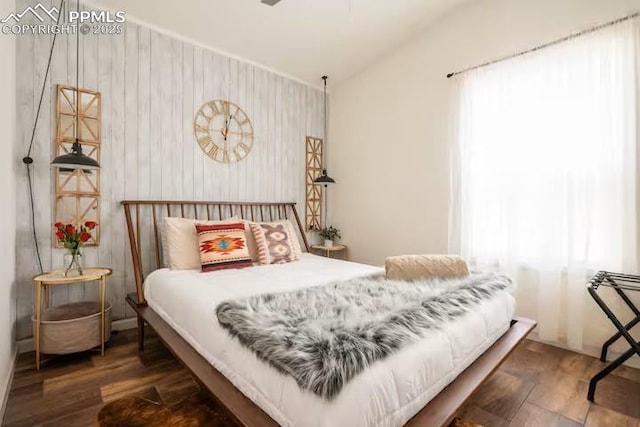 bedroom with lofted ceiling, multiple windows, and wood finished floors