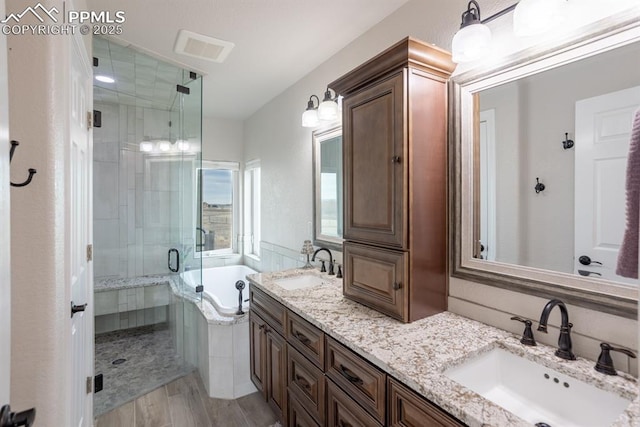 full bath with a garden tub, a sink, a shower stall, and double vanity