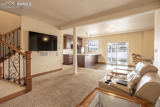 living area with light carpet, stairs, and baseboards