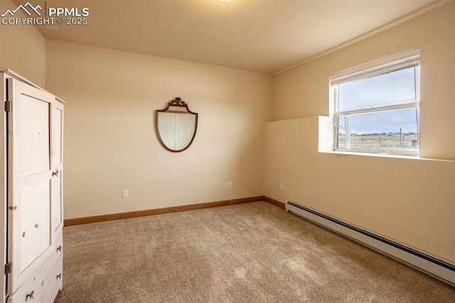 unfurnished room featuring a baseboard heating unit, carpet floors, and baseboards