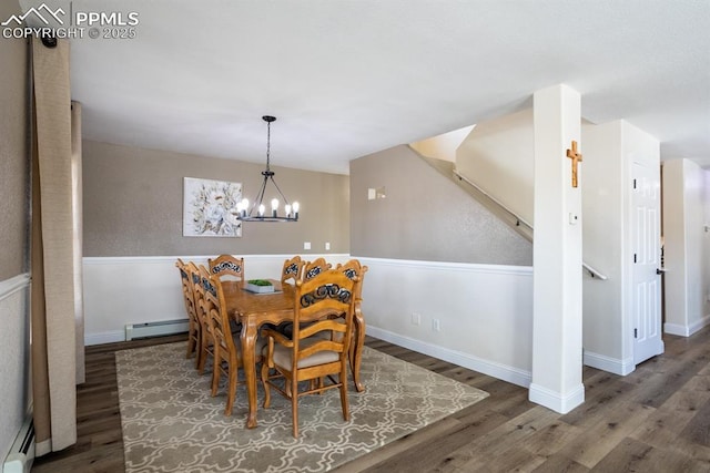 dining area featuring a baseboard radiator, a baseboard heating unit, wood finished floors, a chandelier, and baseboards