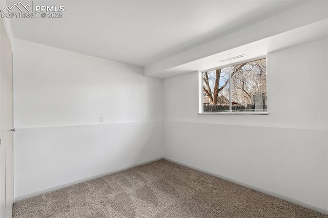 carpeted spare room featuring baseboards