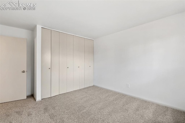 unfurnished bedroom with light carpet and a closet