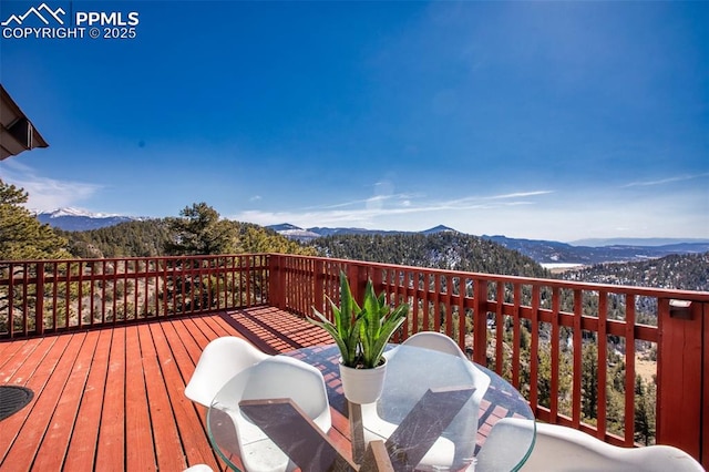 deck featuring outdoor dining space and a mountain view