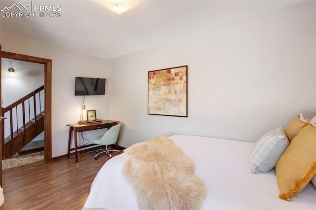 bedroom with baseboards and wood finished floors