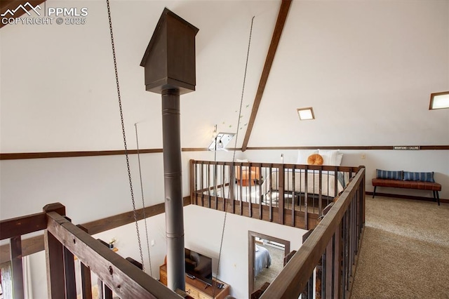 interior space featuring carpet, a towering ceiling, and an upstairs landing