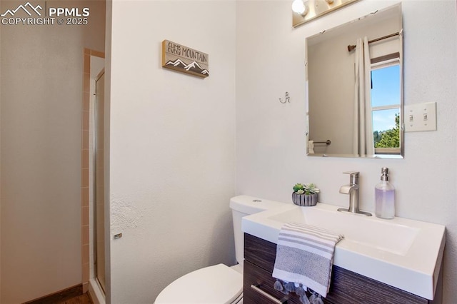 full bath featuring a stall shower, vanity, and toilet