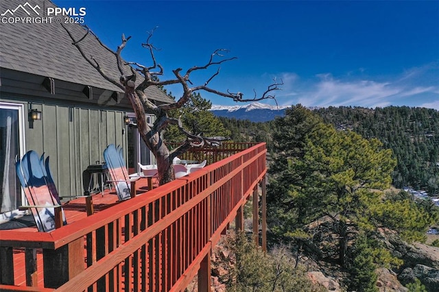 wooden deck featuring a forest view