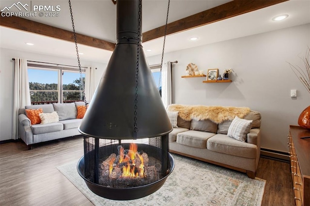 living room featuring a baseboard heating unit, beamed ceiling, wood finished floors, and baseboards