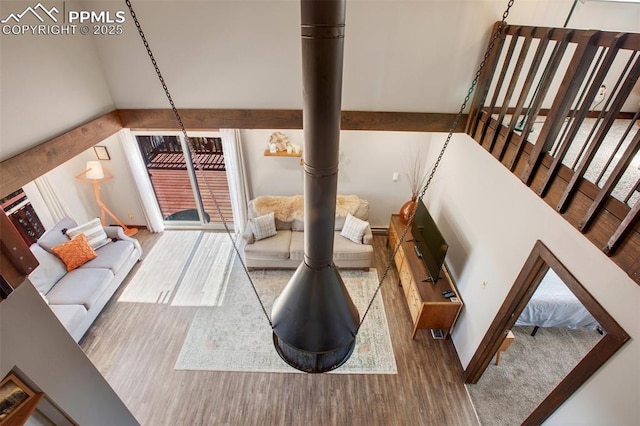 living room featuring a towering ceiling, wood finished floors, and a wealth of natural light