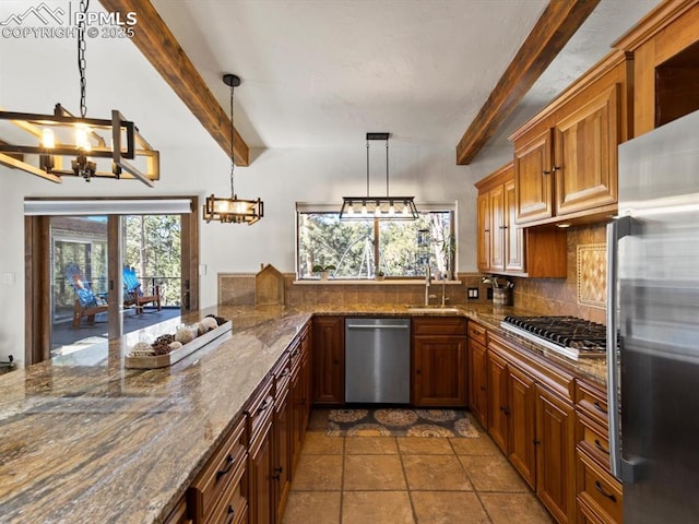 kitchen with a sink, stainless steel appliances, backsplash, and a wealth of natural light