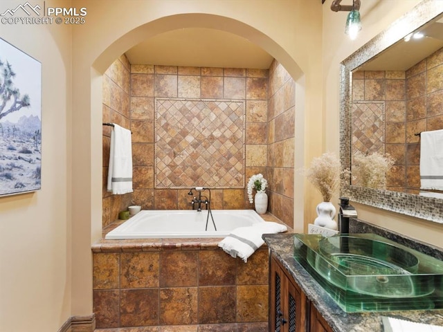 full bath featuring a garden tub and vanity