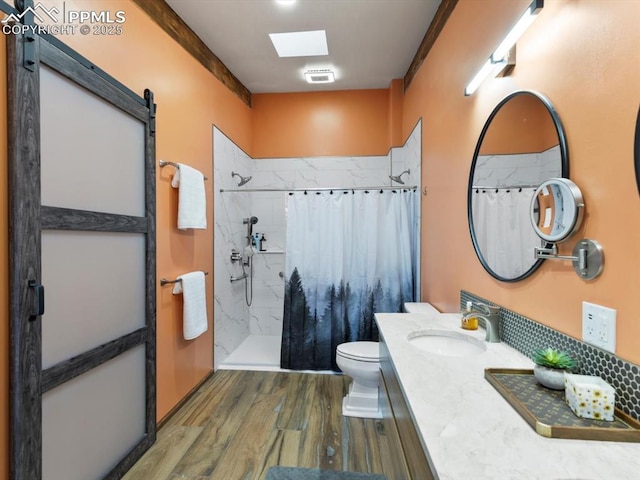 bathroom featuring toilet, a shower with curtain, wood finished floors, and vanity