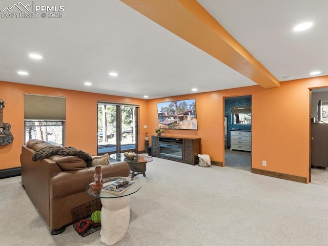 carpeted living area featuring baseboards, a glass covered fireplace, and recessed lighting