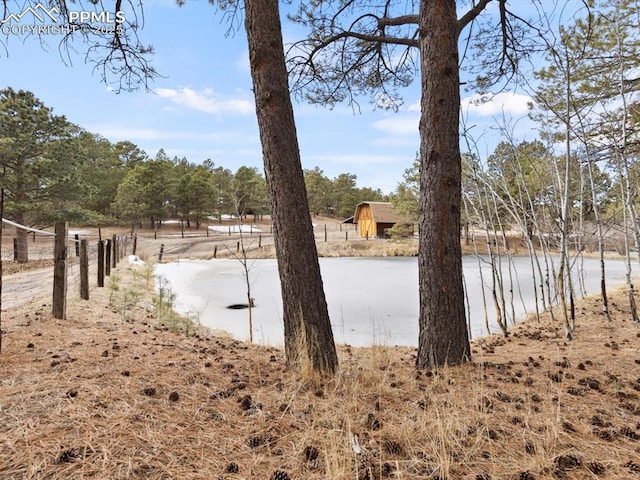 view of yard featuring a water view and fence