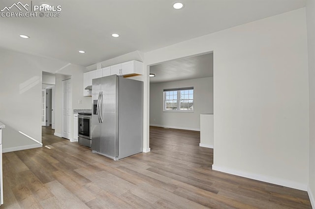 kitchen with stainless steel appliances, wood finished floors, white cabinetry, and recessed lighting