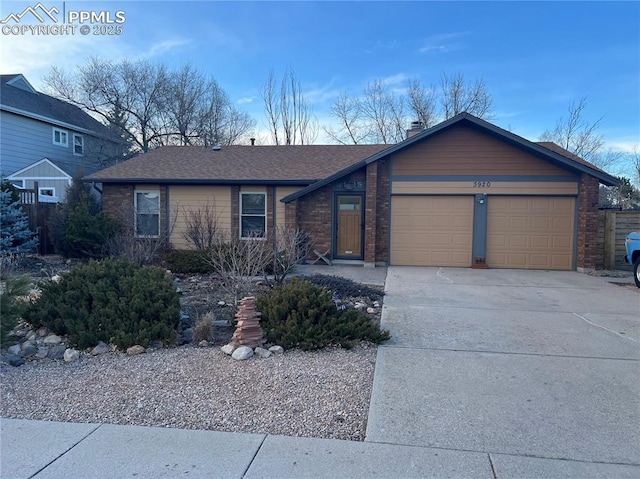 view of front facade with concrete driveway, brick siding, roof with shingles, and an attached garage