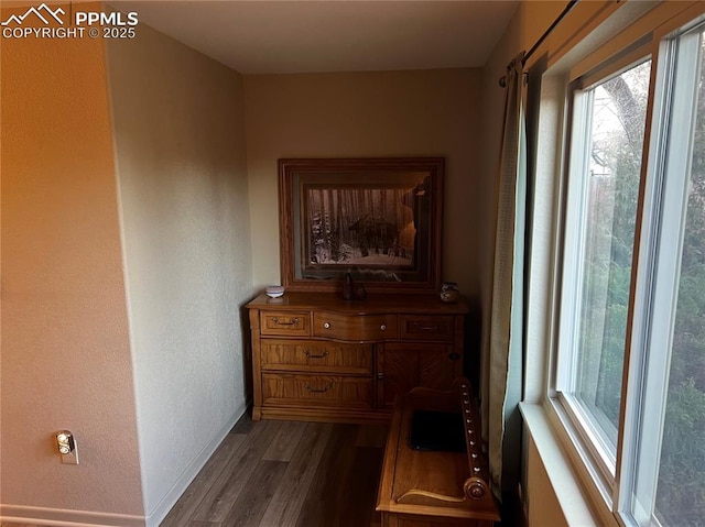 hallway with baseboards and dark wood-type flooring