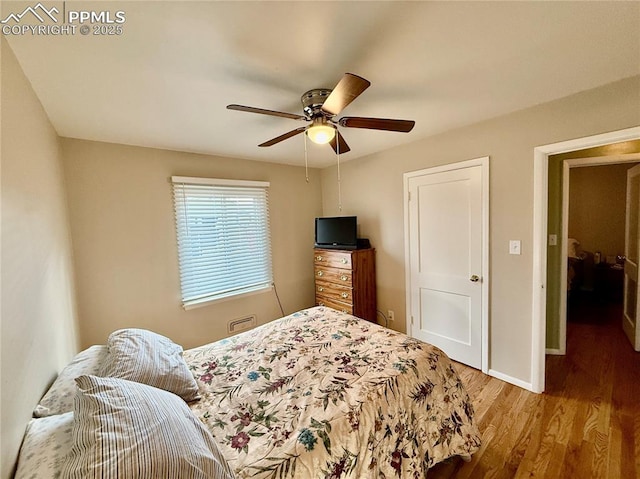 bedroom featuring wood finished floors, a ceiling fan, and baseboards