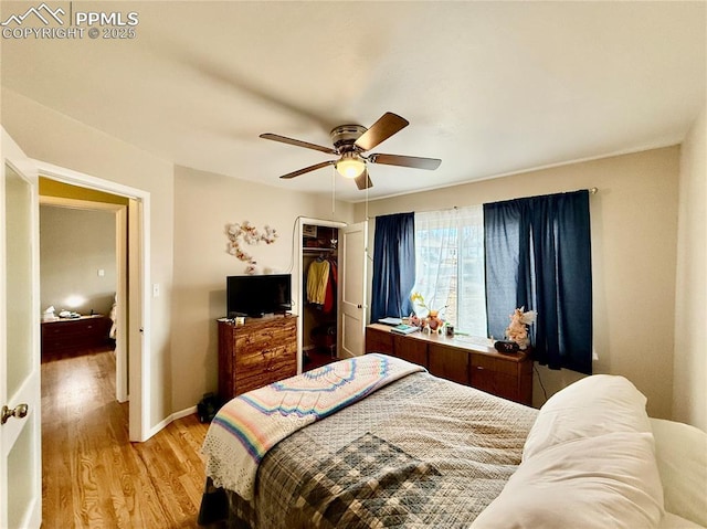 bedroom featuring baseboards, ceiling fan, a closet, and light wood-style floors