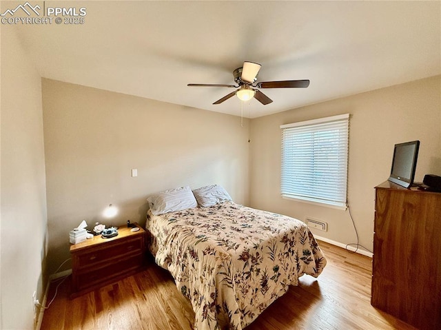 bedroom featuring ceiling fan, wood finished floors, and baseboards