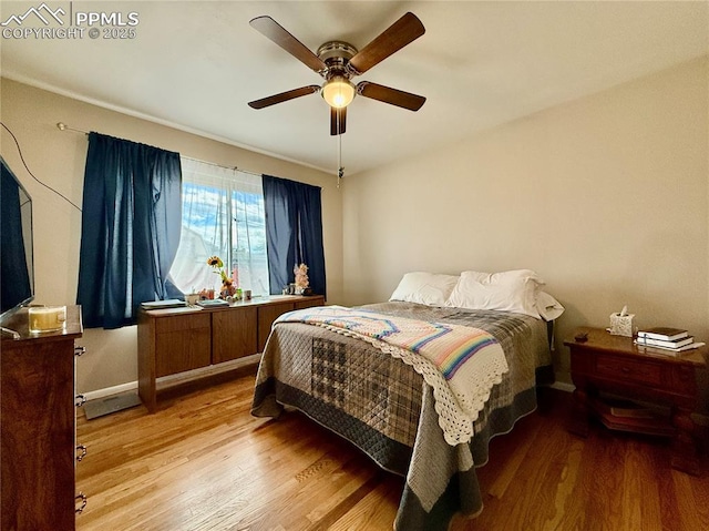 bedroom featuring ceiling fan, wood finished floors, and baseboards