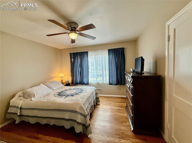 bedroom with wood finished floors, a ceiling fan, and baseboards