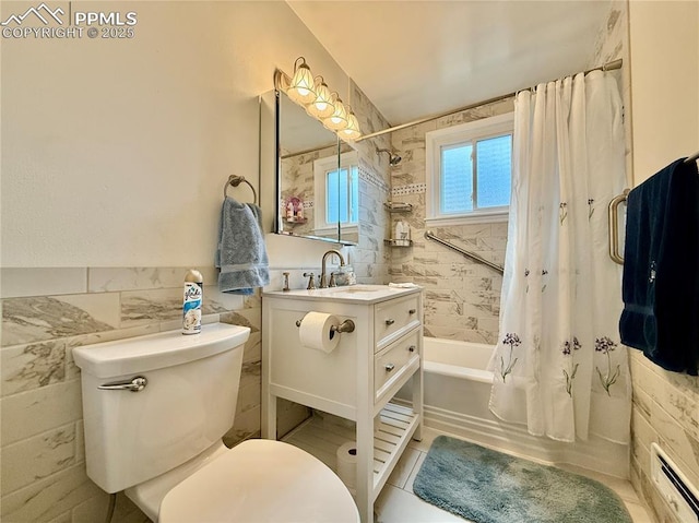 bathroom with tile walls, toilet, shower / bath combo with shower curtain, a baseboard heating unit, and vanity