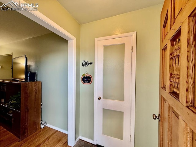 hallway with wood finished floors and baseboards