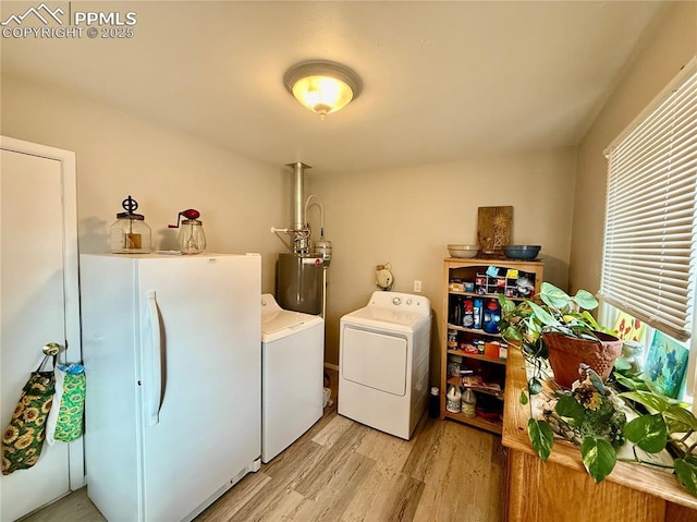 laundry area with laundry area, light wood-style flooring, water heater, and washer and dryer