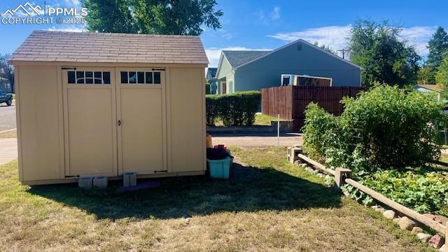 view of shed featuring a vegetable garden and fence